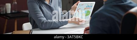 Smiling Woman Pointing at Tablet with Data Charts Header Image Stock Photo