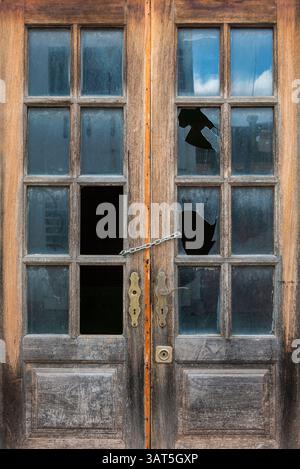 Old wooden door with broken windows Stock Photo