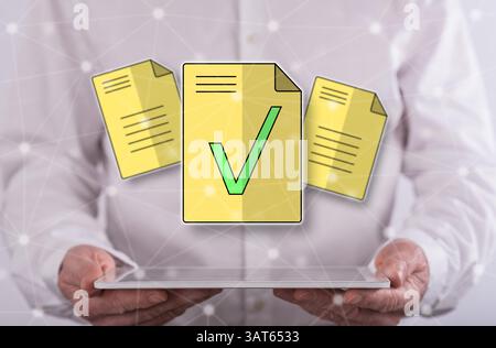 Document validation concept above a tablet held by a man in background Stock Photo
