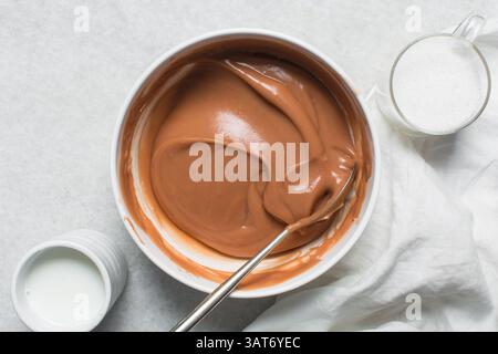 Overhead view of nigerian akamu being made in a white bowl, pap akamu or ogi in a white bowl, top view of nigerian guinea corn pudding in ramekin Stock Photo