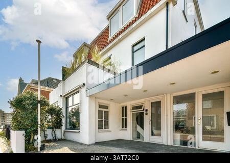 Contemporary architecture featuring a stylish facade and landscaped surroundings in a vibrant urban setting, showcasing modern living spaces. Stock Photo