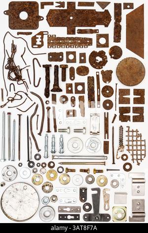 A group of various old and new bits and pieces arranged on white. Old rusty nuts, bolts, nails and other parts flay lay on white background. Stock Photo