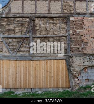 Detail of an old timber-framed house wall with bricks, laths, and clay Stock Photo