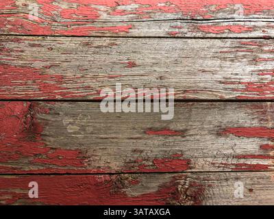 Old rustic wooden boards background with red peeling paint Stock Photo