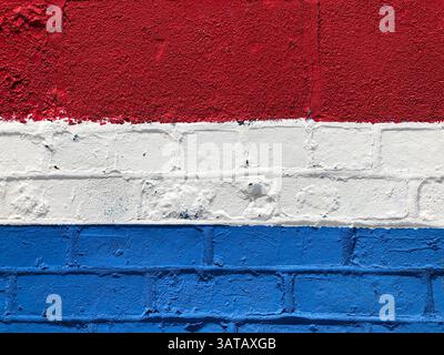 Textured brick wall painted in the red white and blue colors of the Netherlands Stock Photo