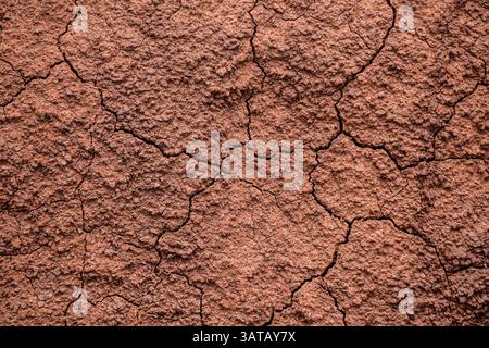 Cracked dry red clay soil background Stock Photo