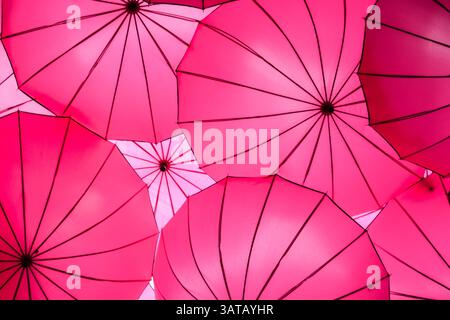 Multiple bright pink umbrellas background Stock Photo