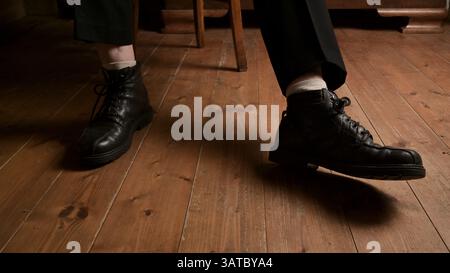 Old leather shoes handmade by the shoemaker at home on the wooden floor. Stock Photo