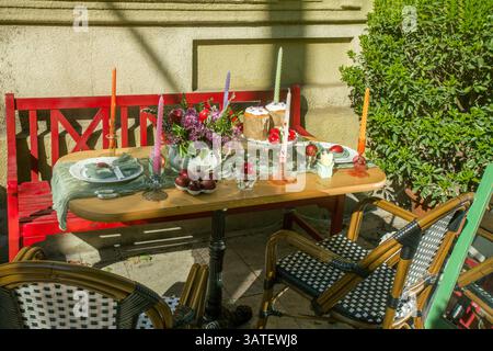 Easter baked goods (kulich, Easter bread), eggs painted red, candles on the festive  (ceremonial) table - Easter is coming soon!  Lilac flowers - on t Stock Photo