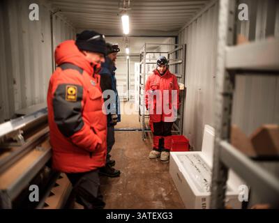 Two scientists and a technician after depositing the first box of ice cores in the storage tunnel. Little Dome C, Antarctic Plateau, Antarctica Stock Photo