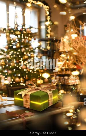 Give gifts under the Christmas tree with Christmas candles and lights at home on Christmas Eve. Stock Photo
