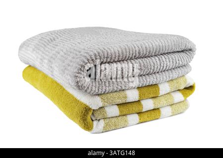 Soft fluffy striped grey and yellow bath towels folded in stack isolated on white background. Terry cloth, striped pattern towel texture, cotton bath Stock Photo