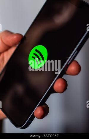 Kaliningrad, Russia 14.01.25 - Woman holding smartphone with SPOTIFY application on screen. Online music app. Stock Photo