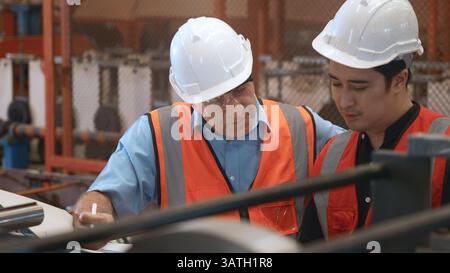 Engineer teaching apprentice to use metal sheet stamping machine Stock Photo