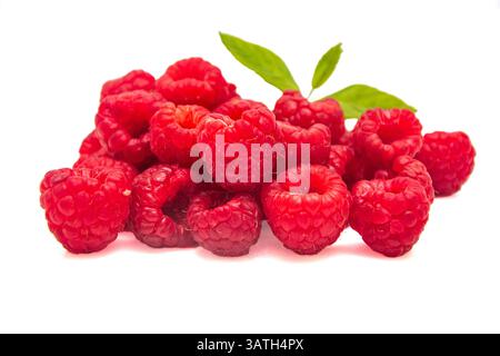 Heap of raspberries with green leaves on white isolated background Stock Photo