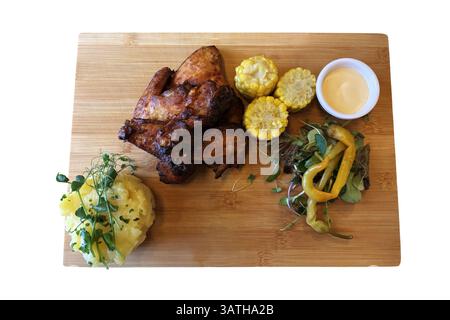 Grilled chicken wings, mashed potatoes, pepper salad and corn and sauce on wooden board, tasty dish of traditional Czech cuisine, isolated object soft Stock Photo