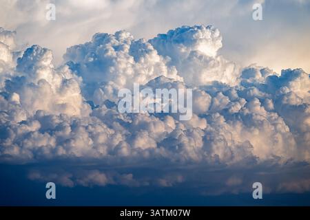 Cumulus clouds gather intricately over Doñana, showcasing a vibrant sky filled with dynamic patterns and shades of blue and white. Stock Photo