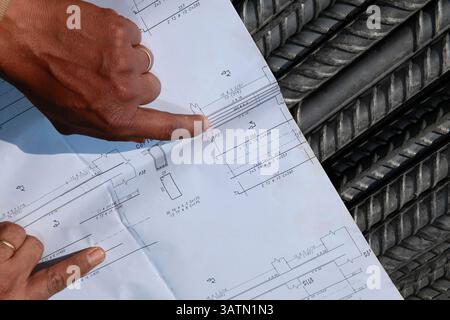 Sao Paulo, Brazil -  jul 19, 2013 - workers review the construction plan on top of steel bars Stock Photo