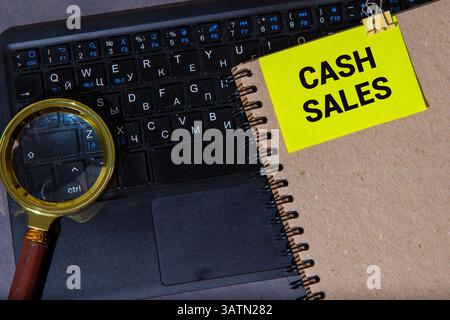 On the table there is a red marker and a white paper tablet on which the text is written - CASH sales, red and black letters. Business concept. Stock Photo