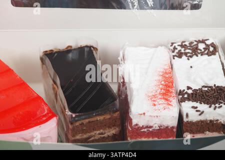Assorted slices of colorful cakes displayed in a box Stock Photo
