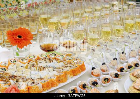 A lot of sushi rolls and drinks on buffet table, catering Stock Photo
