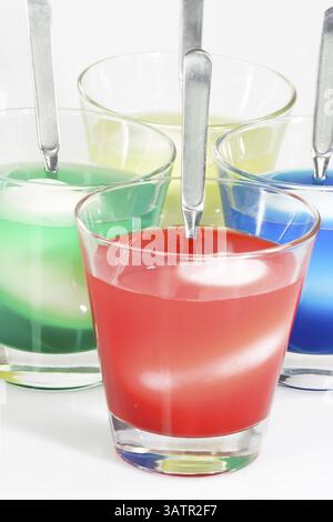 Easter eggs in a jar with food colouring Dyeing colourful Easter eggs on bright Background Stock Photo