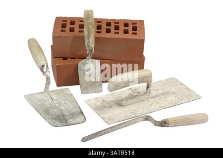 Used trowels with red bricks - isolated on white background Used trowels with red bricks - isolated on white background Stock Photo