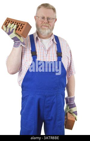 Bricklayer with blue dungarees holds bricks in his hand Stock Photo