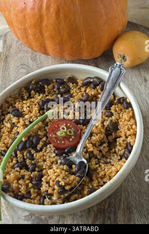 Oriental munchies: bulgur salad with black beans, a pumpkin in the background Stock Photo