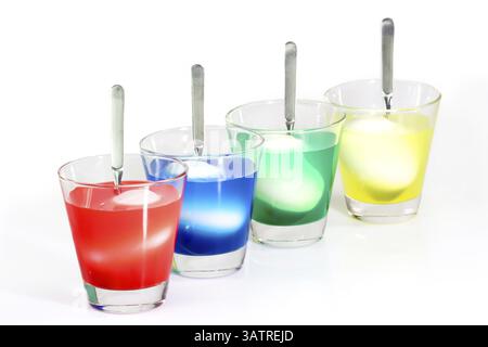 Easter eggs in a jar with food colouring Dyeing colourful Easter eggs on bright Background Stock Photo