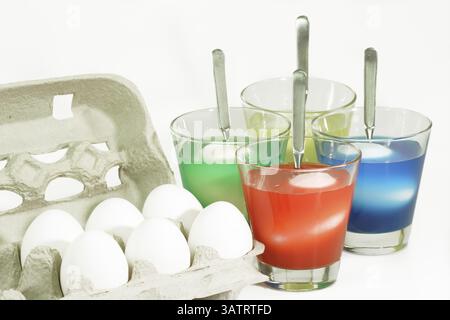 Easter eggs in a jar with food colouring Dyeing colourful Easter eggs on bright Background Stock Photo