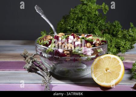 Plate with sald, lemon and greenery on a wooden table Stock Photo