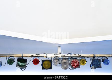 Set of stage suspended coloured spotlights under ceiling with copy space Stock Photo