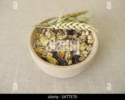 Fruit muesli with wholegrain flakes and dried fruit in a wooden bowl Stock Photo