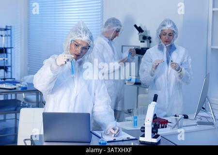 Scientists working with computers and samples in laboratory Stock Photo