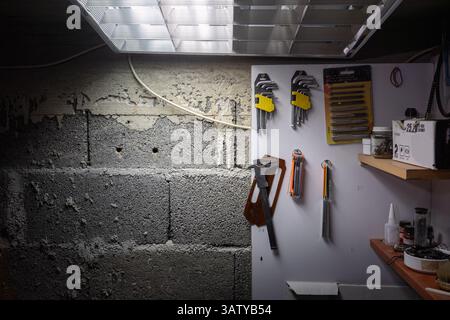 Details of a craft workshop, a wall with hanging tools. Stock Photo