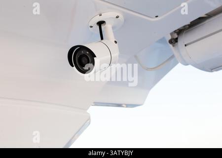 CCTV camera on the hull of an expensive motor yacht. CCTV camera white on a white body. Stock Photo
