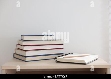 Books, notebook and pencil on wooden table indoors. Space for text Stock Photo