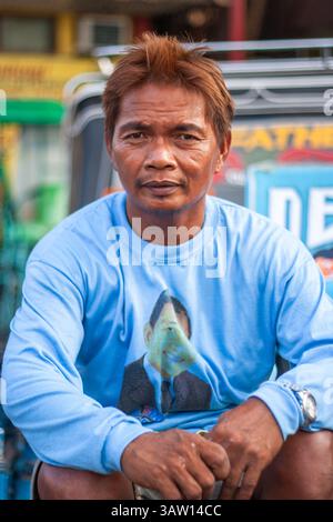 Portrait of a mature Filipino man wearing a sky blue long-sleeved shirt and sporting blonde dyed hair, photographed in Cebu, Philippines Stock Photo