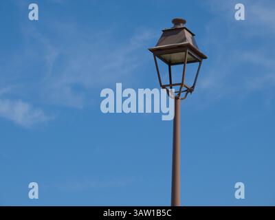 Vintage Street Lamp Against a Clear Blue Sky with Light Clouds, Corse, France Stock Photo