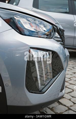 Close-up of the front of a modern car, highlighting the stylish headlight and aggressive design elements of the front bumper. Stock Photo