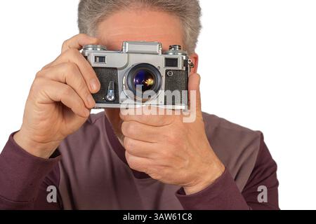 A man is holding a vintage camera, ready to capture the moment, embodying a love for photography and classic equipment. Stock Photo