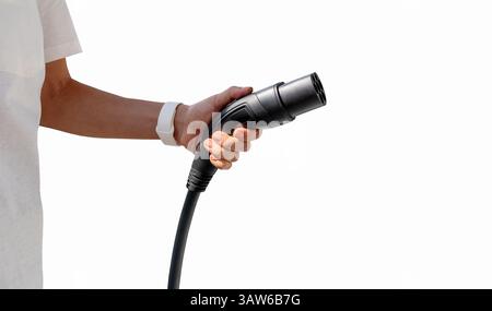 Isolated female person holding black EV charging connector. Stock Photo