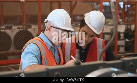 Engineer teaching apprentice to use metal sheet stamping machine Stock Photo