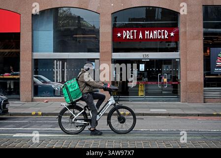 Uber Eats delivery cyclist waits in traffic on Princes Street, Edinburgh, Scotland, UK. Stock Photo