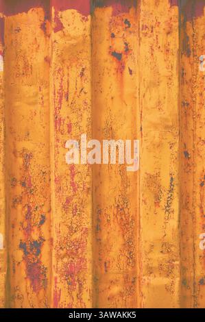 Yellow grunge sea freight container background, dark rusty corrugated pattern, red primer coating, vertical rusted detailed steel texture, crakcked Stock Photo