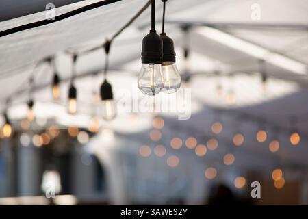 A view of hanging vintage style lightbulbs inside an event style tent. Stock Photo