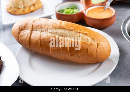A view of a pre-sliced dinner roll on a plate. Stock Photo