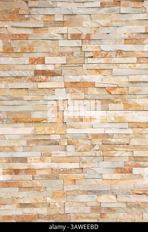 A view of a wall facade of horizontal stacked tan and beige stones, as a background. Stock Photo