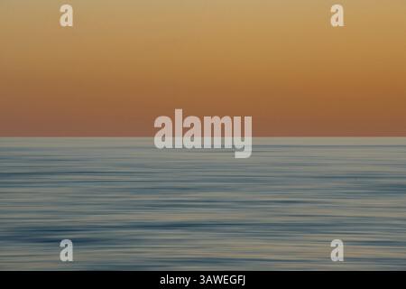 Abstract motion-pan image of the sea at Free Castelletto Beach at sunset. Spiaggia libera del Castelletto, Finale Ligure, Savona, Italy. Stock Photo